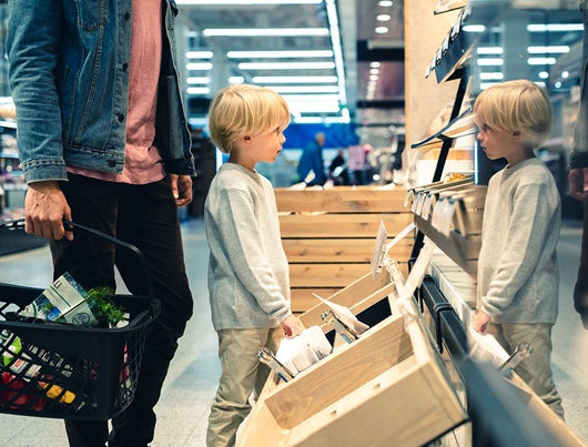 A dad and his child in a supermarket.