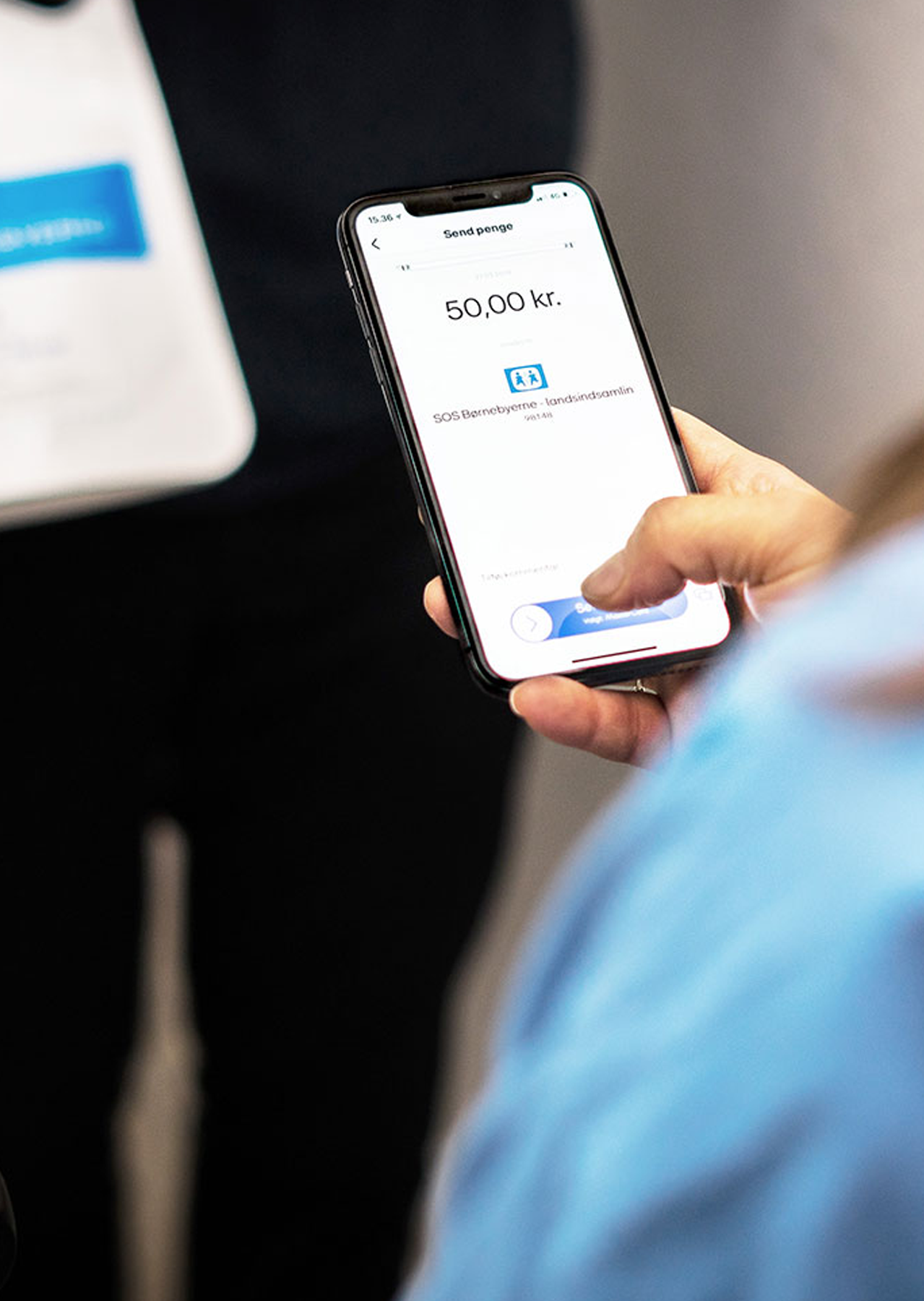 Billede af kvinde og indsamler, hvor kvinde betaler til indsamling med MobilePay.