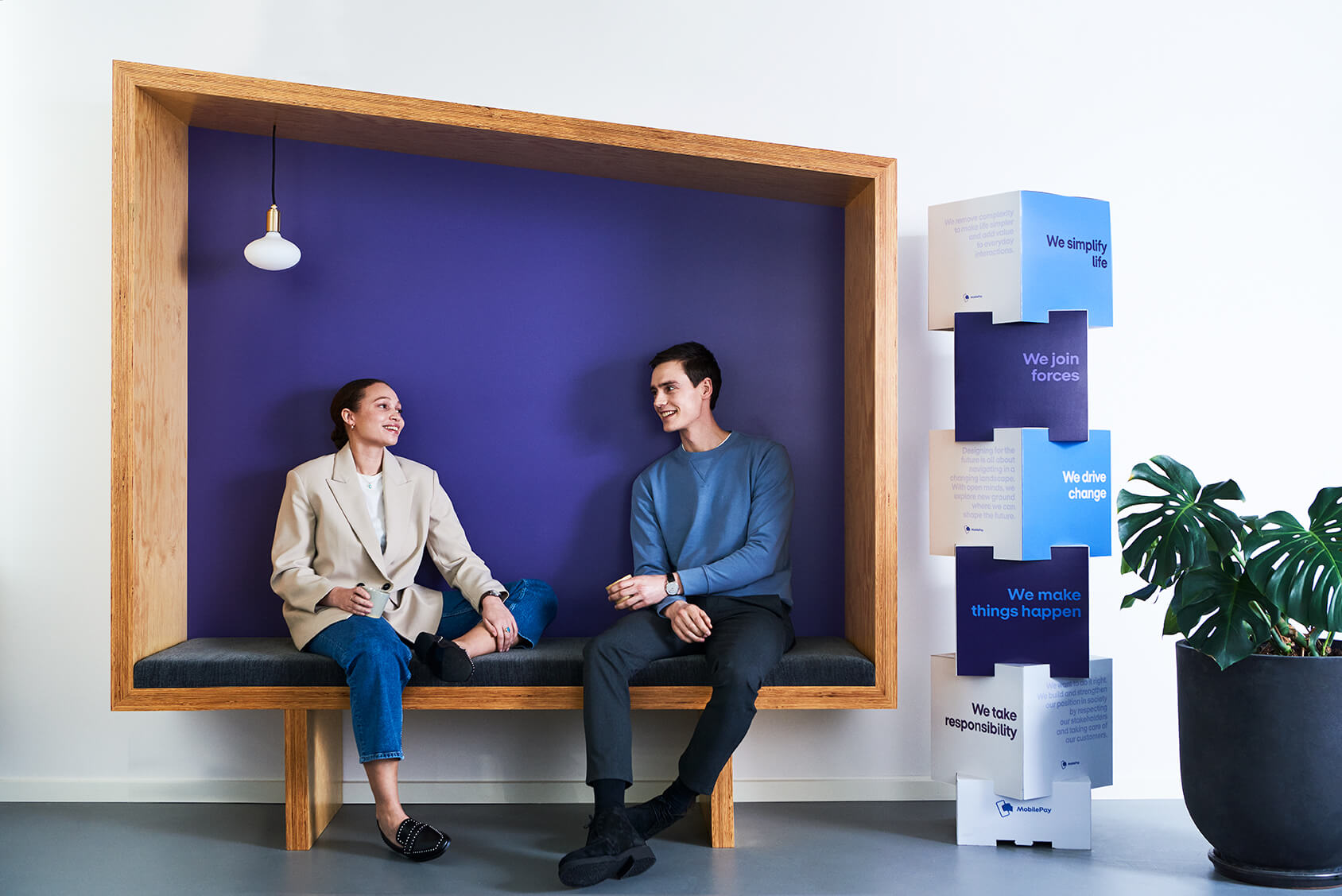 Two employees talking and laughing on a bench at the office